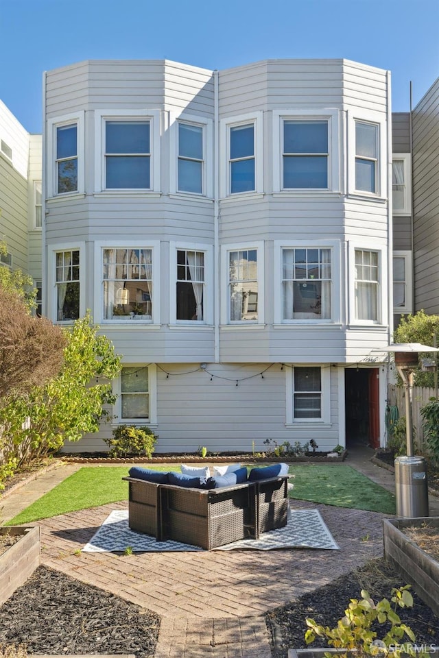 back of house with outdoor lounge area and a patio area