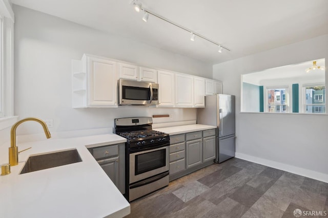 kitchen featuring sink, white cabinets, gray cabinetry, an inviting chandelier, and appliances with stainless steel finishes