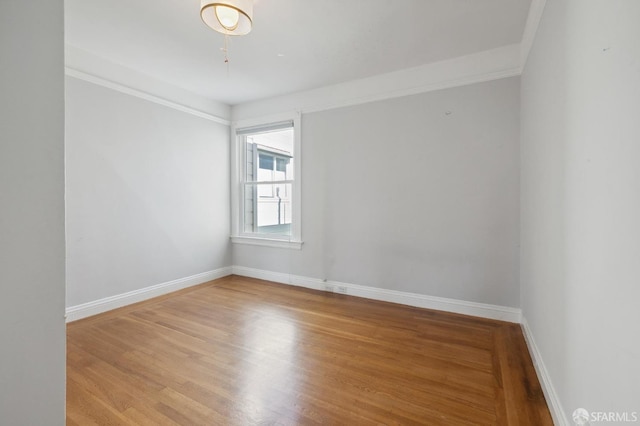 spare room featuring hardwood / wood-style floors and crown molding