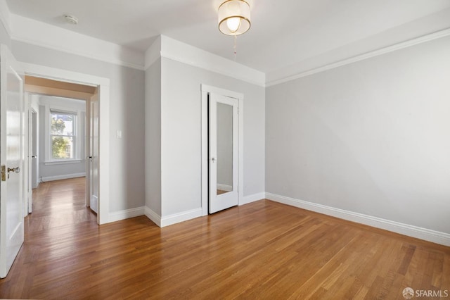 unfurnished bedroom featuring wood-type flooring and ornamental molding