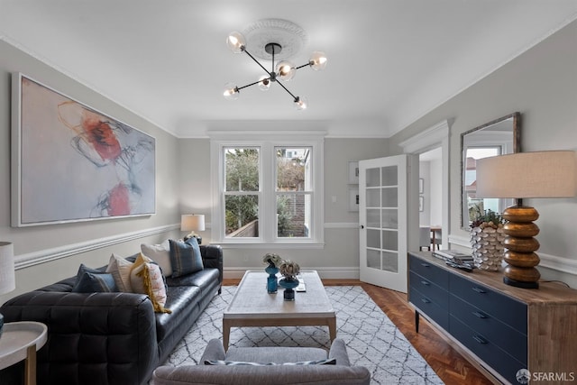 living room featuring crown molding, an inviting chandelier, and parquet floors