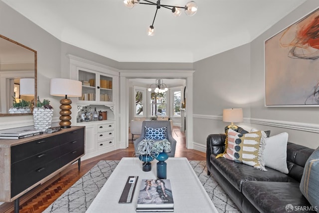 living room with built in shelves and an inviting chandelier