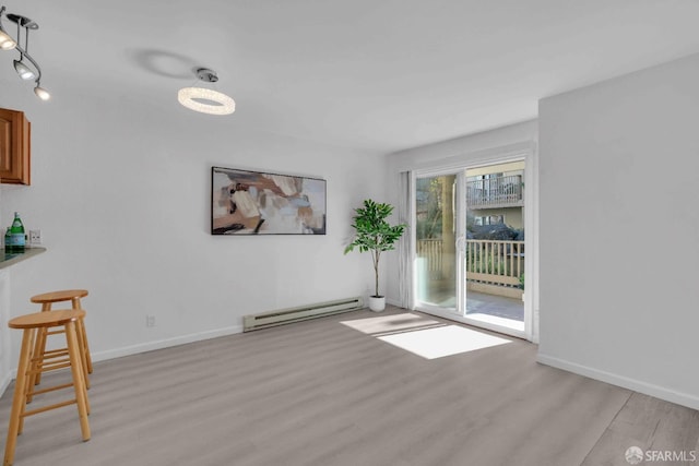 interior space with light hardwood / wood-style flooring and a baseboard heating unit