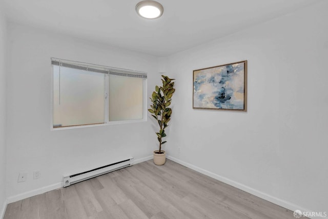 unfurnished room with light hardwood / wood-style flooring and a baseboard heating unit