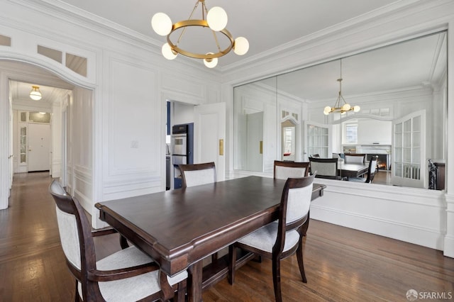 dining space with a chandelier, dark hardwood / wood-style flooring, and ornamental molding