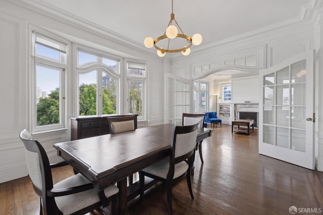 dining space featuring crown molding, french doors, and an inviting chandelier