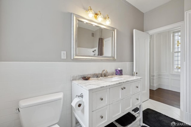 bathroom featuring tile patterned flooring, vanity, tile walls, and toilet