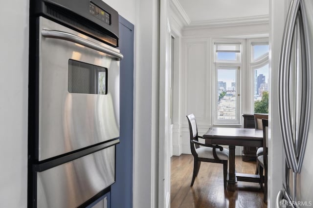 kitchen with dark hardwood / wood-style flooring, ornamental molding, and appliances with stainless steel finishes