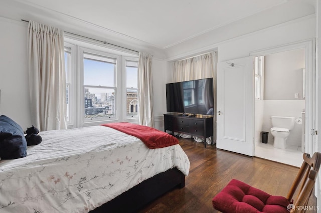 bedroom with dark wood-type flooring and connected bathroom