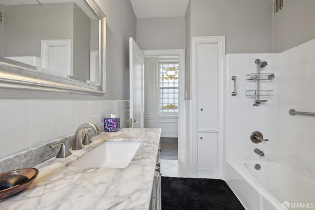 bathroom featuring tile patterned floors, vanity, and tiled shower / bath