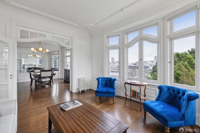 sunroom featuring radiator and a notable chandelier