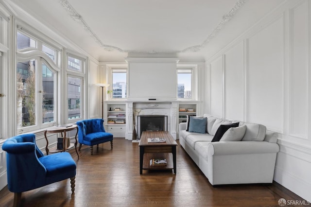 living room with crown molding, a premium fireplace, and dark hardwood / wood-style floors