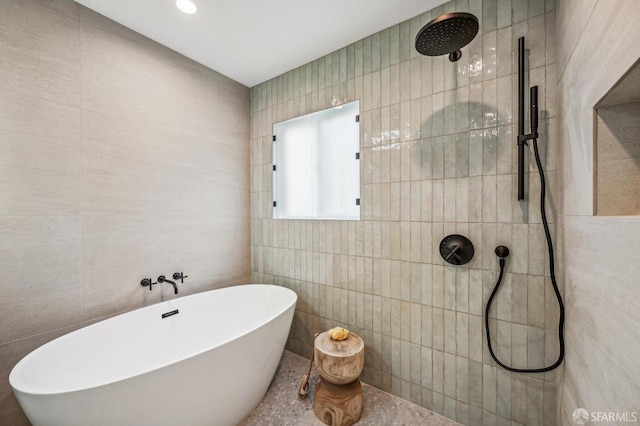 bathroom with tile walls and shower with separate bathtub