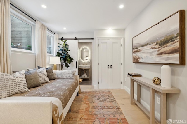 interior space with a barn door and light hardwood / wood-style floors