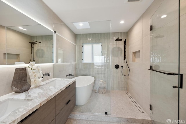 bathroom featuring vanity, plus walk in shower, and tile walls