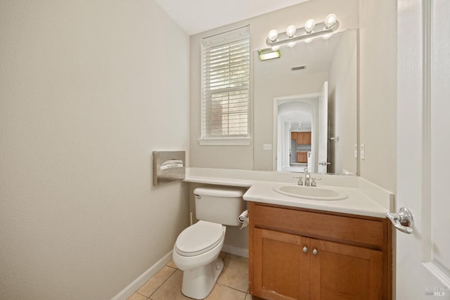 bathroom featuring toilet, vanity, tile patterned floors, and vaulted ceiling