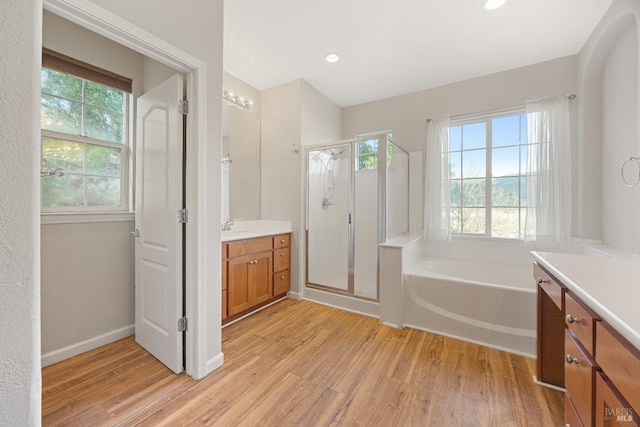 bathroom featuring hardwood / wood-style floors, vanity, and separate shower and tub