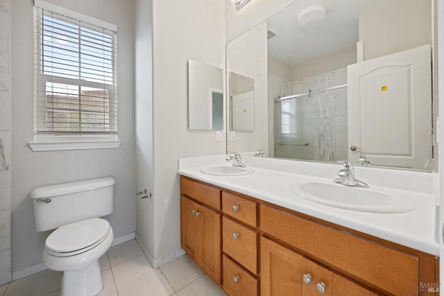 bathroom featuring tile patterned flooring, vanity, toilet, and tiled shower