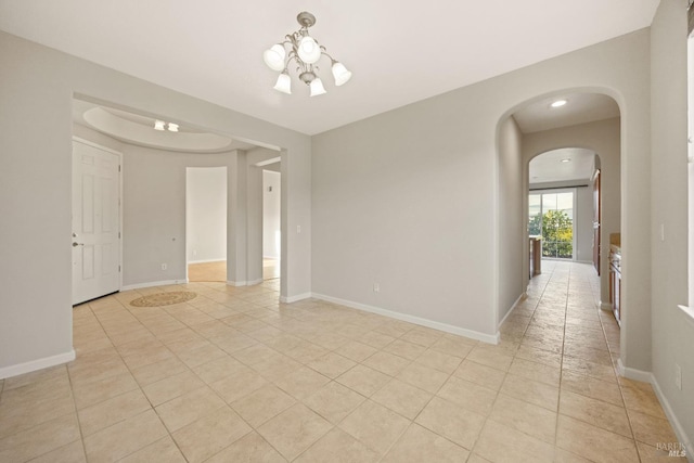 spare room featuring light tile patterned floors and an inviting chandelier