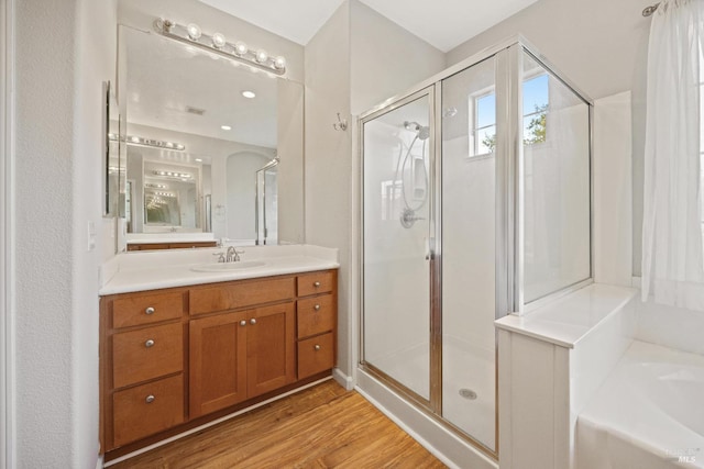 bathroom with vanity, wood-type flooring, and shower with separate bathtub