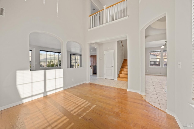 unfurnished room with a high ceiling and hardwood / wood-style flooring