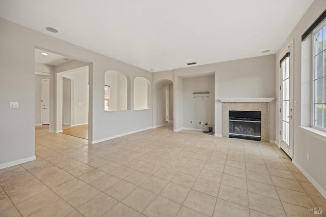 unfurnished living room with light tile patterned floors and a fireplace