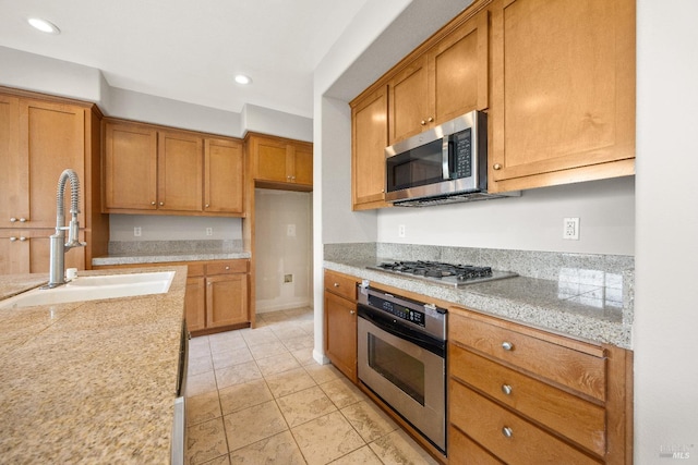 kitchen with sink, light tile patterned flooring, and appliances with stainless steel finishes