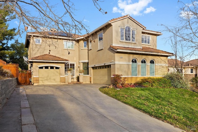 mediterranean / spanish home featuring solar panels, a garage, and a front lawn