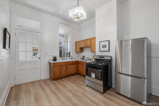 152-154 Ord St, San Francisco, CA 94114 - kitchen with stainless steel appliances, light countertops, a chandelier, light wood-style floors, and pendant lighting