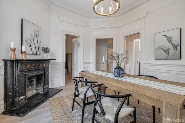 152-154 Ord St, San Francisco, CA 94114 - dining space featuring a decorative wall, crown molding, a chandelier, light wood-type flooring, and a premium fireplace