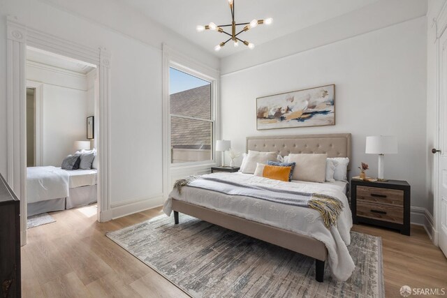152-154 Ord St, San Francisco, CA 94114 - bedroom featuring a chandelier, wood finished floors, and baseboards
