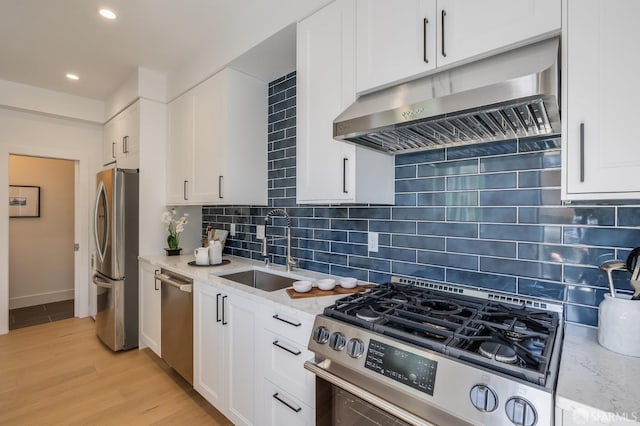 152-154 Ord St, San Francisco, CA 94114 - kitchen with stainless steel appliances, exhaust hood, a sink, light stone counters, and white cabinetry