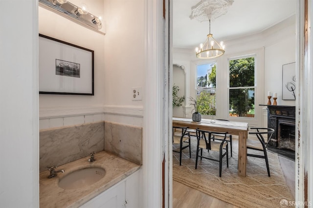 152-154 Ord St, San Francisco, CA 94114 - bathroom with a chandelier, wood finished floors, a sink, a fireplace, and ornamental molding