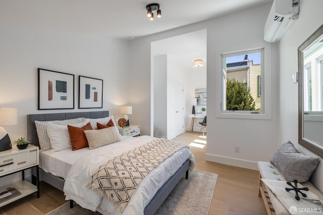 152-154 Ord St, San Francisco, CA 94114 - bedroom featuring multiple windows, a wall mounted AC, light wood finished floors, and baseboards