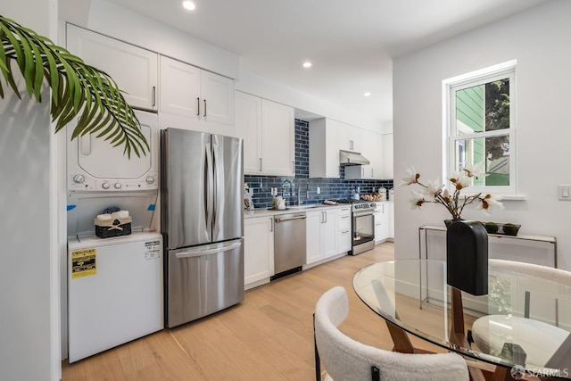 152-154 Ord St, San Francisco, CA 94114 - kitchen with appliances with stainless steel finishes, under cabinet range hood, light wood-style floors, backsplash, and light countertops