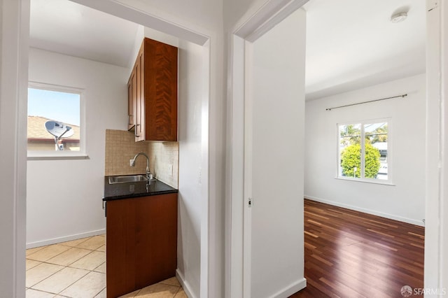 906 40th St, Oakland, CA 94608 - bar area with a sink, decorative backsplash, baseboards, and light wood-style floors