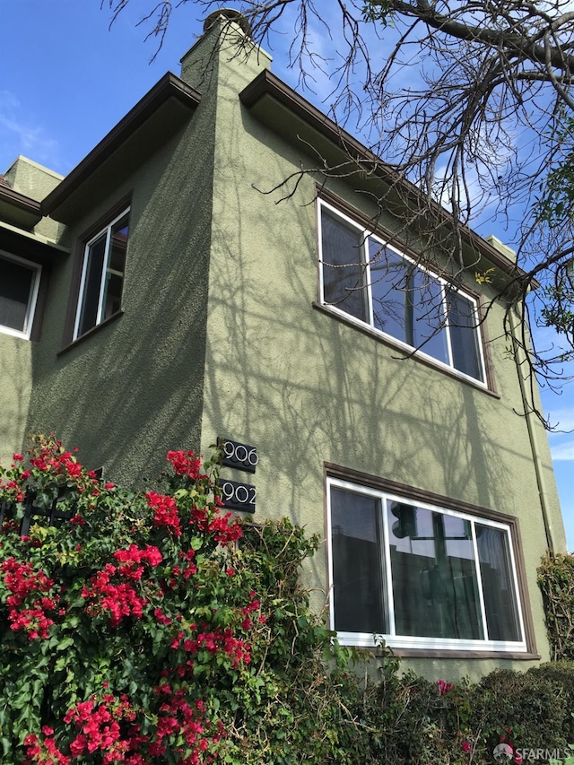906 40th St, Oakland, CA 94608 - view of side of property featuring stucco siding and a chimney