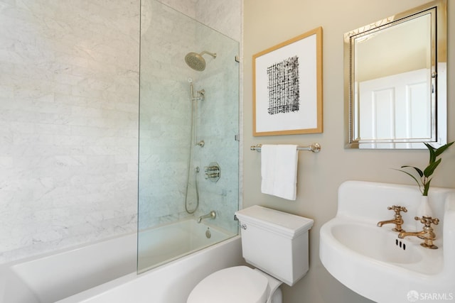 full bathroom featuring a sink, toilet, and bath / shower combo with glass door