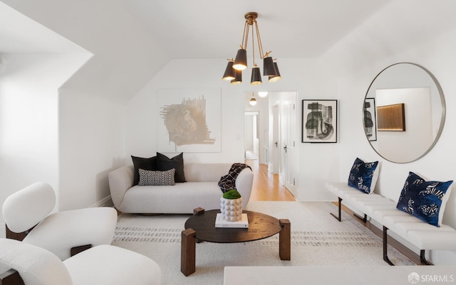 living area featuring lofted ceiling, an inviting chandelier, and wood finished floors