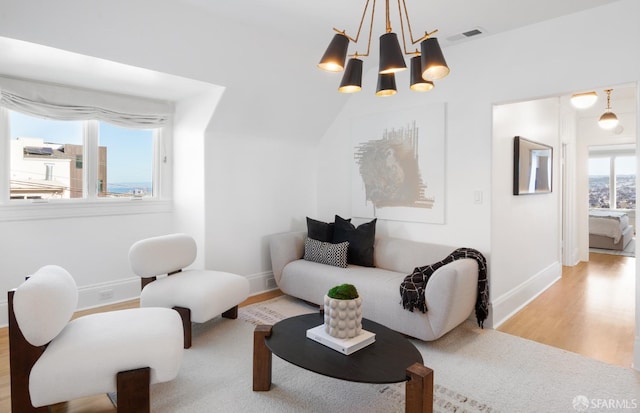 sitting room featuring baseboards, a notable chandelier, visible vents, and wood finished floors