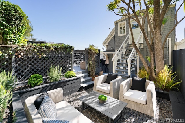 view of patio / terrace featuring stairs, an outdoor hangout area, and fence