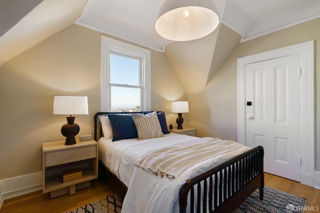 bedroom featuring vaulted ceiling and wood finished floors