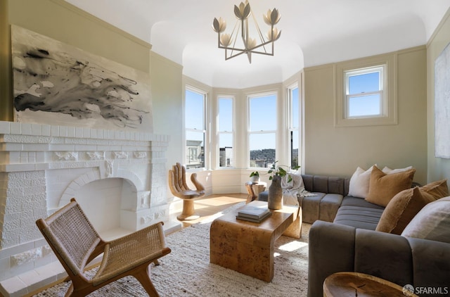 sitting room featuring plenty of natural light, a fireplace, and a chandelier