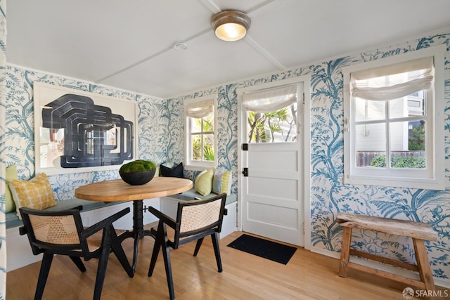 dining room featuring breakfast area, light wood-type flooring, and wallpapered walls