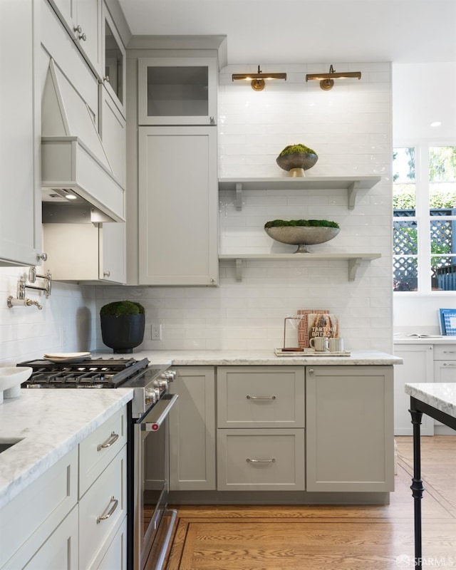 kitchen featuring light wood-style floors, custom exhaust hood, high end range, and gray cabinetry