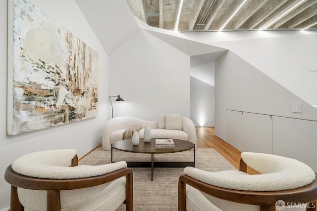 sitting room with light hardwood / wood-style floors and lofted ceiling