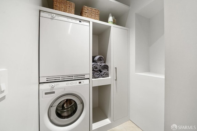 washroom featuring stacked washing maching and dryer