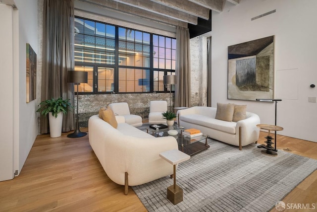 living room featuring beam ceiling and hardwood / wood-style flooring