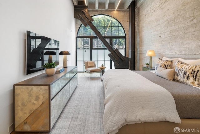 bedroom featuring beamed ceiling and a towering ceiling