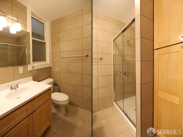 bathroom with tile walls, vanity, an enclosed shower, tile patterned floors, and toilet